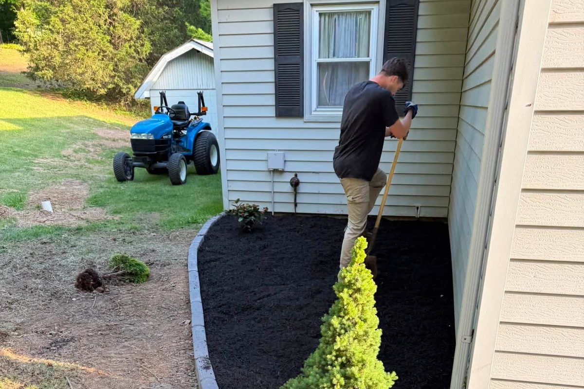 Whitnel's Contracting crew member finishing a new mulch bed