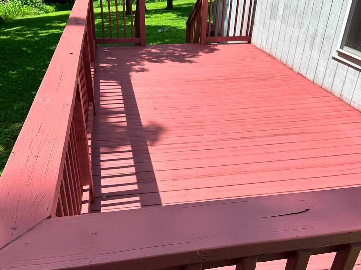 Resurfaced deck stained deep red with a matching railing